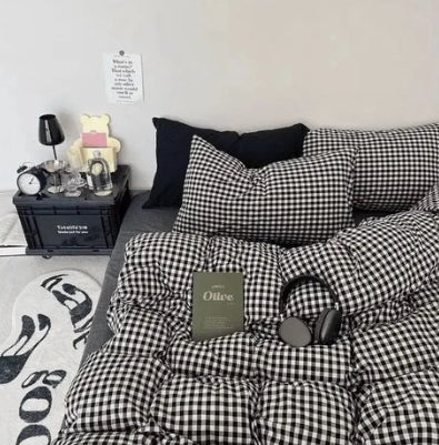 Black and white checkered bedding set on a bed with a nightstand and decor items.